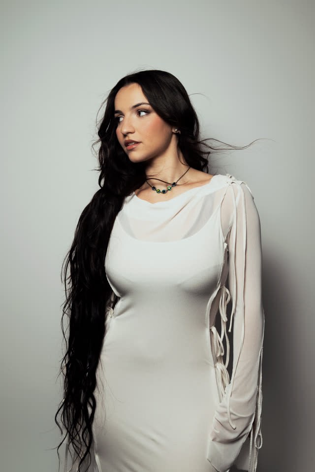 Myla en robe blanche sur fond gris