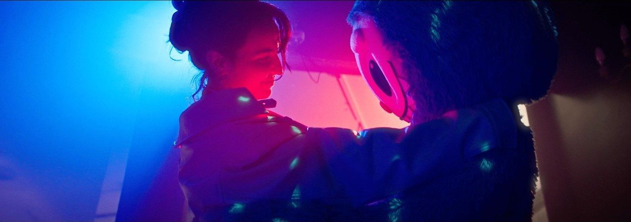 Une scène du clip de Is It a Crime ?, sous une lumière rose et bleue