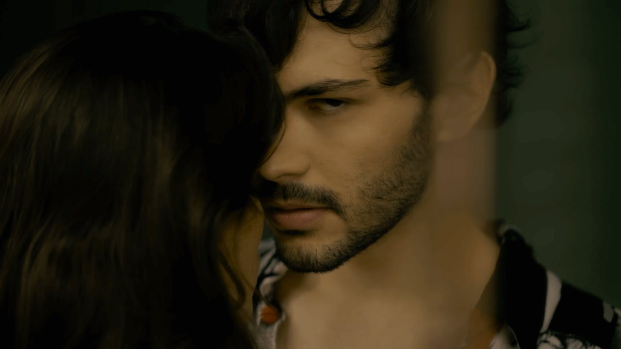 Une scène du clip de Body : un homme et une femme face à face dans une lumière tamisée