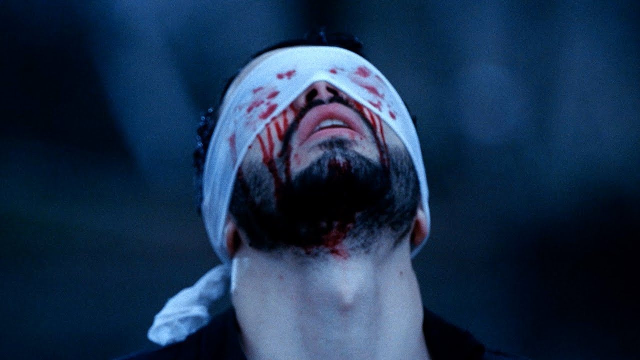 Une scène du clip de Faith : un homme, les yeux couverts d’un bandage taché de sang